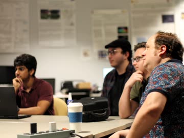 Lab members seated around a table during a project discussion