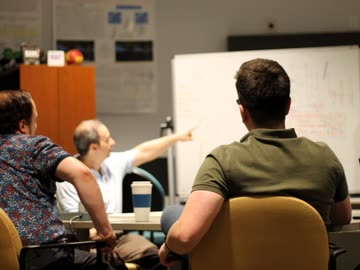 Lab members seated around a table during a project discussion