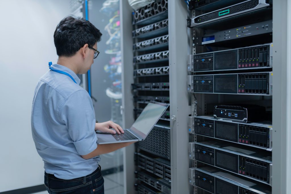 guy with a laptop in a server room